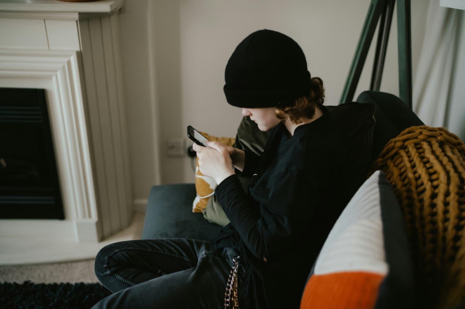 Person sitting on a couch absorbed in their phone